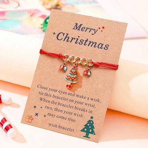Christmas wish bracelet featuring red cord, gold chain, and festive enamel tree charm