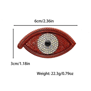 Evil eye brooch with red and white rhinestones showing dimensions 6cm by 3cm
