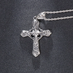 Detailed close-up of a silver gothic cross pendant with intricate star relief patterns