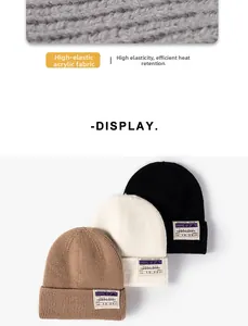 Detail of high-elastic acrylic knit fabric and vintage woven labels on winter beanies