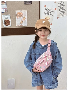 Pink cartoon kids waist bag with rabbit prints shown on a young girl model outdoors