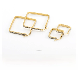 Macro shot of two sets of square gold hoop earrings featuring sparkling crystal pavé settings