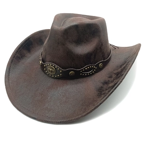 Detail of vintage brown cowboy hat with leather band and bull head metal emblem