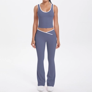 Détail du pantalon de yoga évasé avec taille haute croisée et liserés blancs contrastants