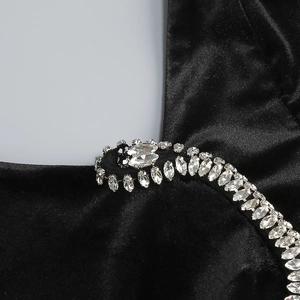 Detail of black velvet dress featuring luxury silver rhinestone and bead embellishments