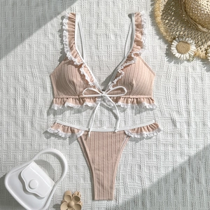 Close-up of apricot pink bikini set with white lace ruffles and bow tie detail