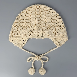 Détail d'un bonnet au crochet fait main avec motifs floraux creux et glands