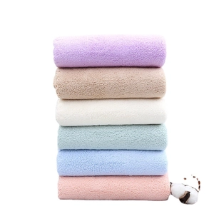 Six macaron-colored coral fleece towels stacked vertically showing soft, plush texture