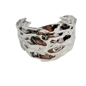Irregular textured silver C-shaped cuff bracelet with a polished molten metal finish