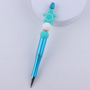 Close-up of blue beaded ballpoint pen featuring a cute silicone sea turtle topper