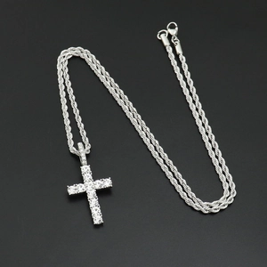 Detailed close-up of hip hop silver cross pendant with sparkling zircon inlays on a rope chain