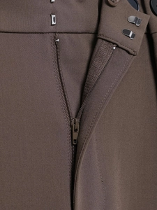 Detailed close-up of brown trousers waist featuring zipper fly and metal hook closure