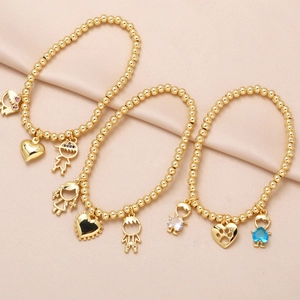 Gold beaded bracelet with heart, boy, and girl charms featuring colorful zircon accents