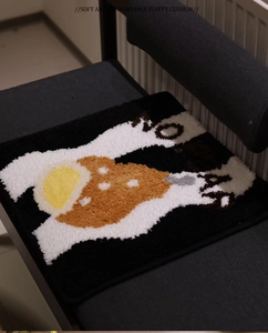 Detail of plush square cushion with 'NO' pattern on black chair in a cozy room