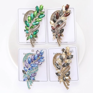 Close-up of elegant crystal wheat brooch pins in four vibrant gradient color variants