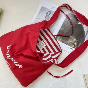 Détail du sac en toile rouge avec imprimé Bonjour et doublure intérieure rayée