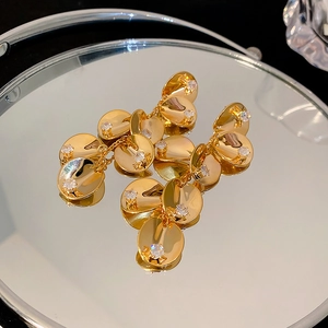 Detail of golden tassel earrings with round sequins and zircon on a mirror tray