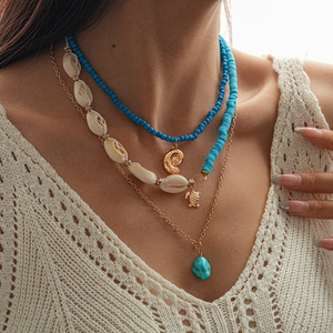 Detail of bohemian layered necklace with turquoise beads, seashells and turtle pendants