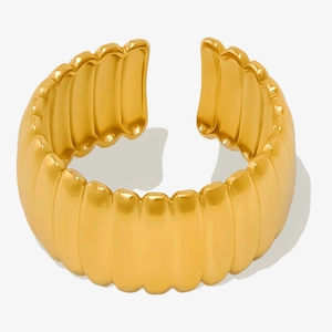Macro detail of golden ribbed geometry ring made of polished 18k vacuum plated stainless steel