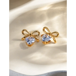 Close-up of 18k gold stainless steel bow earrings with hanging heart zircon stone