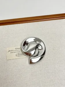 Macro shot of minimalist silver irregular round brooch with polished mirror finish on cloth