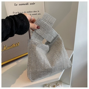 Detail shot of a silver rhinestone evening handbag with a stylish knotted top handle