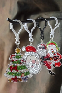 Detail of DIY Christmas diamond painting keychains featuring Santa and tree designs