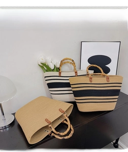 Detail of woven tote bags with bamboo handles in solid khaki and striped patterns