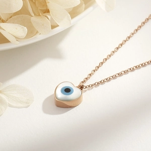 Close-up of 18k gold plated heart necklace with evil eye and white shell inlay