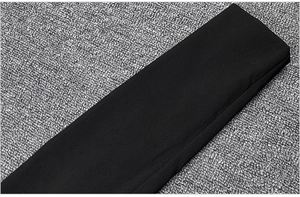 Detail view of black long sleeve cuff with matte texture on high-waisted skirt suit