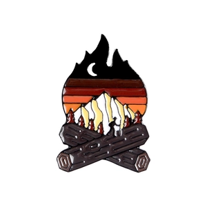 Outdoor camping enamel pin featuring campfire, mountains and sunset on a white background