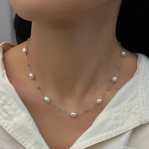 Elegant freshwater pearl necklace featuring silver chain worn by model for a minimalist look