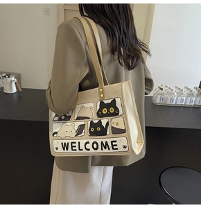 Detail of beige canvas tote bag with cute cat print and khaki PU shoulder straps
