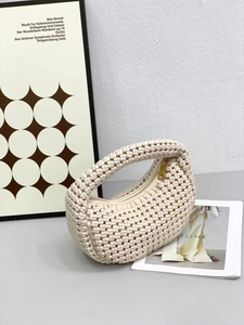 Detail view of beige woven hobo bag with sleek metal zipper on a minimalist background