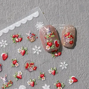 Detail of 3D embossed nail stickers featuring strawberries, rabbits, and white snowflakes