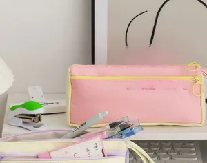 Macro shot of large capacity pink and yellow canvas stationery bag with dual metal zippers