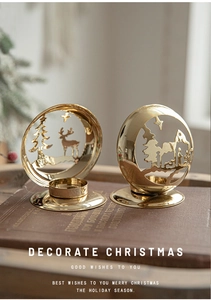 Close-up of golden hollow Christmas candle holders with reindeer and star patterns