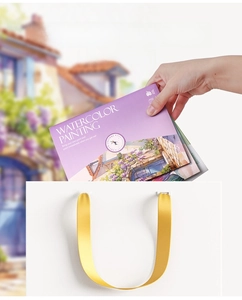 Portable watercolor painting book with 12 colors being placed into a handbag