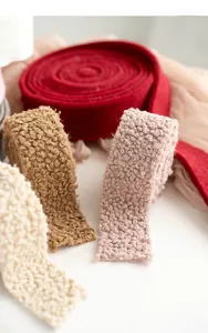 Close-up of textured Christmas wool felt ribbons in burgundy and beige for DIY crafts