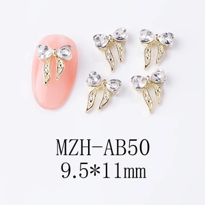 Vue macro de décoration d'ongle nœud doré 9,5x11mm avec cœur en cristal brillant