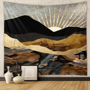 Close-up of lightweight fabric tapestry with abstract black and gold mountain sunrise design