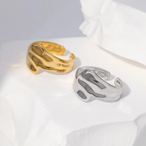 Detail of minimalist wave lava rings in gold and silver finish with textured surface