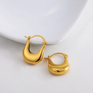 Detailed view of U-shaped teardrop gold earrings with highly polished mirror finish