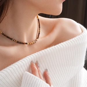 Vintage square tiger eye stone necklace with brown beads on a white knit sweater