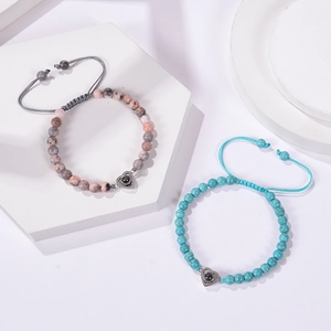 Close-up of pink zebra stone and turquoise beaded bracelets with heart projection pendants