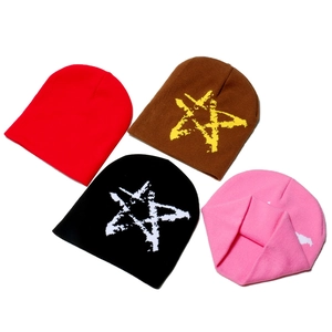 Detailed knit texture of winter star jacquard beanies in red, brown, black and pink colors