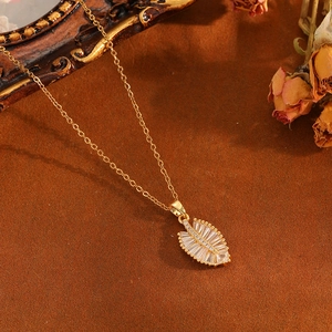 Detail of leaf pendant with pavé crystals on a gold chain in a vintage gift setting