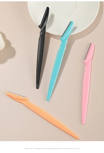 Detail of four colorful eyebrow razors with safety guards on a decorative tray