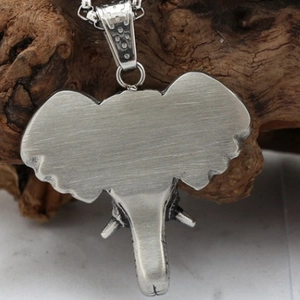 Brushed stainless steel elephant pendant back view on a rustic natural wood surface