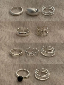 Flat lay of diverse silver adjustable rings with black agate and textured metal designs